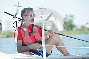 Handsome young man sailing on hobie cat photo
