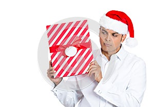 Handsome young man shaking and listening to wrapped gift