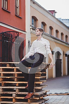 Handsome young man shirt sitting on pallet