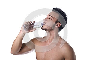 Handsome young man shirtless drinking water from plastic bottle