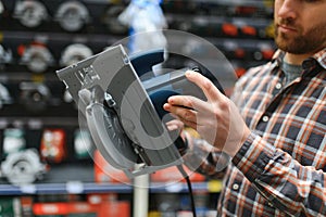 handsome young man shopping for tools at hardware store