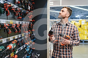 handsome young man shopping for tools at hardware store