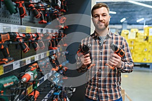 handsome young man shopping for tools at hardware store