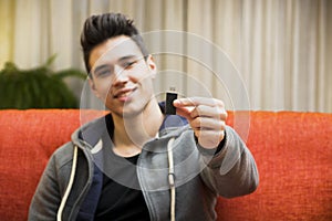 Handsome young man showing USB key in his hand