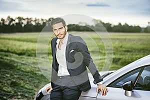 Handsome young man sitting in his car