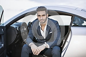 Handsome young man sitting in his car