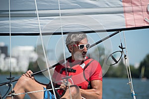 Handsome young man sitting on hobie cat