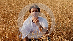 Handsome Young Man Sitting In Wheat Field, Relaxing On Nature