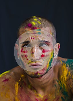 Handsome young man with skin all painted with Holi colors