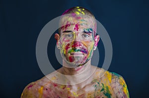 Handsome young man with skin all painted with Holi colors