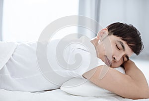 Handsome young man sleeping in bed