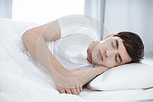 Handsome young man sleeping in bed
