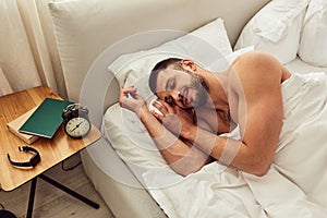 Handsome young man sleeping in bed at home