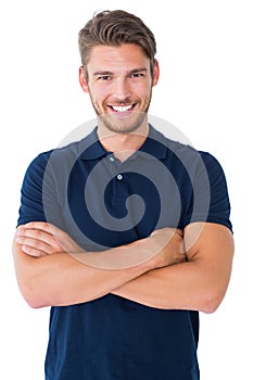 Handsome young man smiling with arms crossed