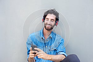 Handsome young man smiling with cellphone and headphones