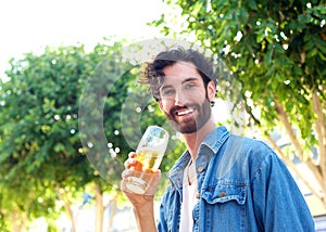 Handsome young man smiling with a glass of beer outdoor