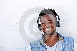 Handsome young man smiling with headphones on white background
