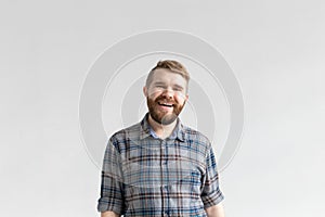 Handsome young man smiling and laughing on white background with copy space