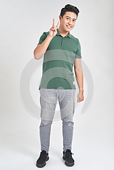 Handsome young man smiling and showing victory sign over isolated white background