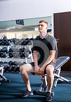 Handsome young man in sportswear having a little break after workout