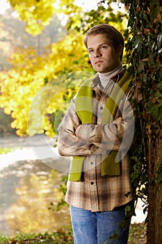 Handsome young man standing at tree outdoor