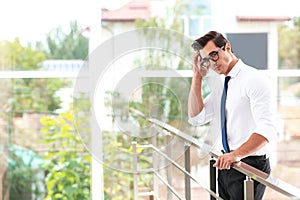 Handsome young man in stylish clothes with glasses indoors