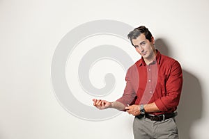 Handsome young man in stylish clothes on light beige background