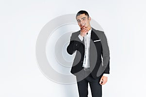 Handsome young man in a stylish suit, posing on a white background isolated