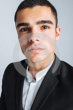 Handsome young man in a stylish suit, posing on a white background isolated