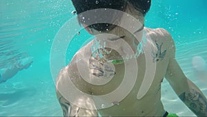 Handsome young man swimming in pool, underwater shot