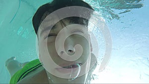 Handsome young man swimming in pool, underwater shot