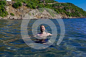 Handsome young man swimming in the sea