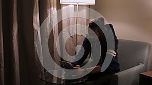 Handsome, young man with tablet computer sitting on chair at home