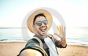 Handsome young man taking selfie with smart mobile phone device at the beach - Happy tourist taking selfie