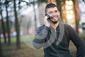 Handsome young man talking on his phone in an urban area