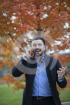 Handsome young man talking on the phone outside