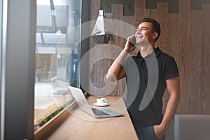 Handsome young man talking on phone and smiling