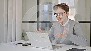 Young Man Talking on Video Chaton Laptop in Modern Office photo