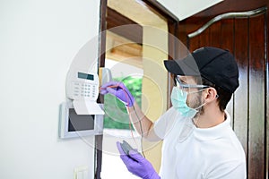 Handsome young man telephone operator worker fixing internet issue connexion at client house with surgical mask and gloves COVID19