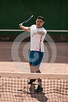 Handsome young man on tennis court.