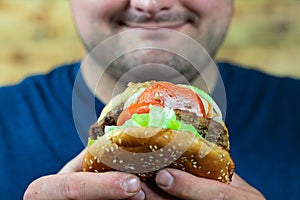 Handsome young man about to enjoy his burger. Fast food goodies