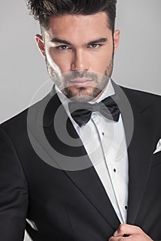 Handsome young man in tuxedo ajusting his jacket