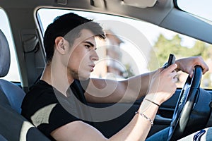 Handsome Young Man Using Cell Phone Driving a Car