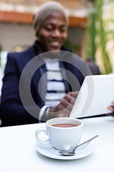 Handsome young man using his digital tablet in the cafe.