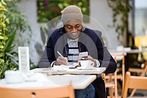 Handsome young man using his mobile phone in the cafe.