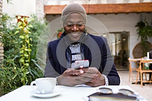 Handsome young man using his mobile phone in the cafe.