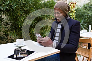 Handsome young man using his mobile phone in the cafe.