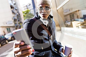 Handsome young man using his mobile phone in the street.