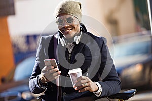 Handsome young man using his mobile phone in the street.