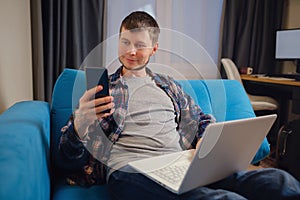 Handsome young man using laptop computer at home.